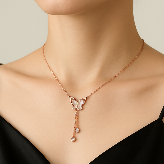 Rose gold necklace with butterfly pendant worn by a model against a neutral background